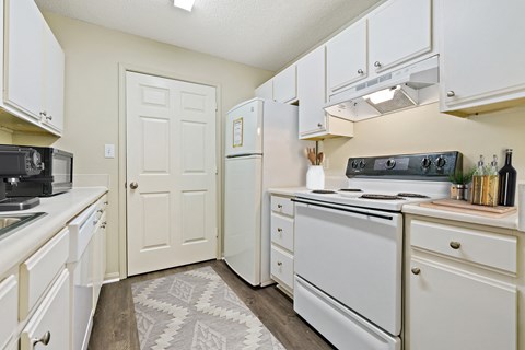 a white kitchen with white appliances and white cabinets at Baldwin Farms Apartments, Robertsdale, Alabama